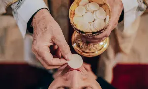 Kapłan podaje Komunię Świętą. Czy można przyjąć komunię świętą dwa razy w ciągu dnia? To pytanie nurtuje wielu wiernych.