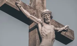 Kamienna rzeźba Jezusa na krzyżu, z wyrazem cierpienia na twarzy. Wzrok skierowany w dół, jakby w geście modlitwy do Jezusa o pomoc w trudnych chwilach.