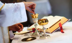Kapłan wkłada opłatek do kielicha. Czy po kłótni można iść do komunii? To pytanie zadaje sobie wielu wiernych.