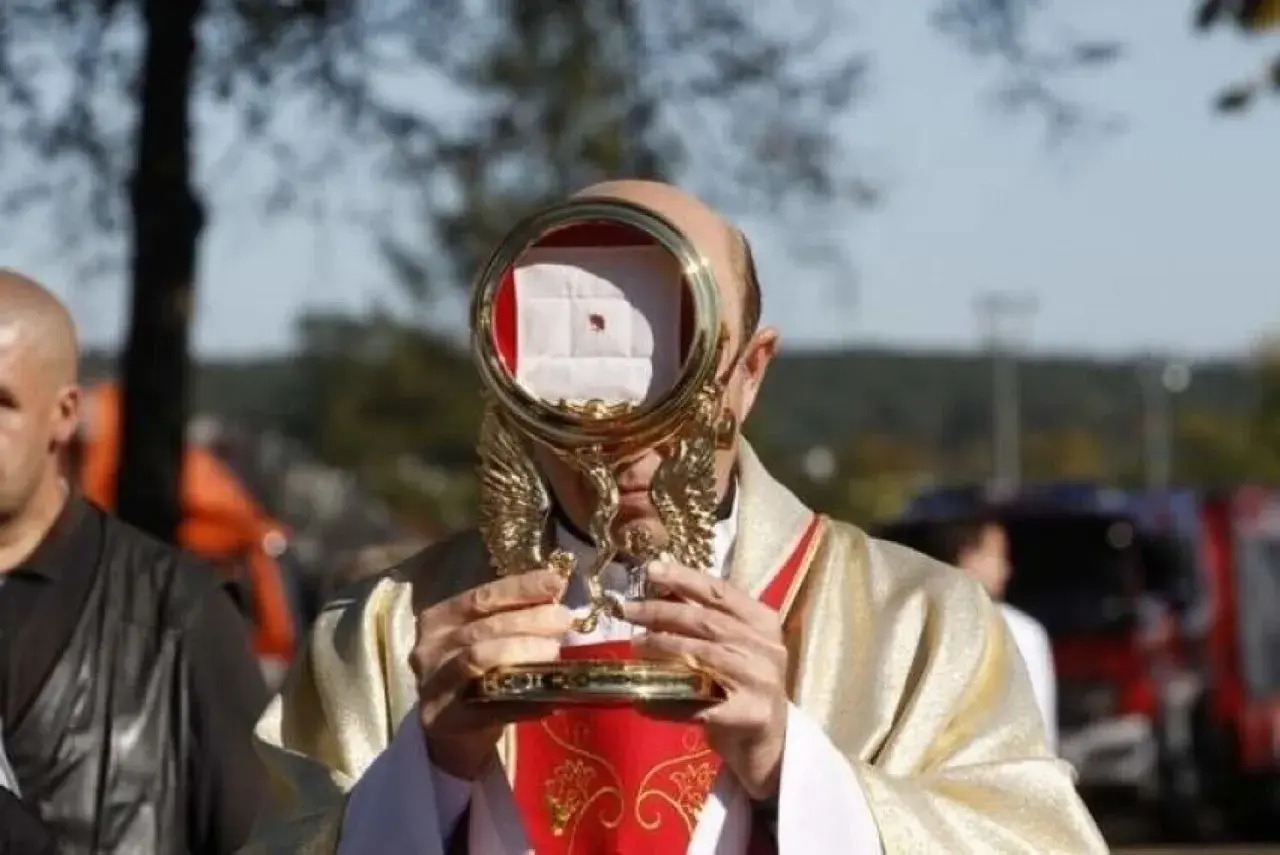 Kapłan trzyma monstrancję z hostią, przypominającą cud eucharystyczny w Sokółce.